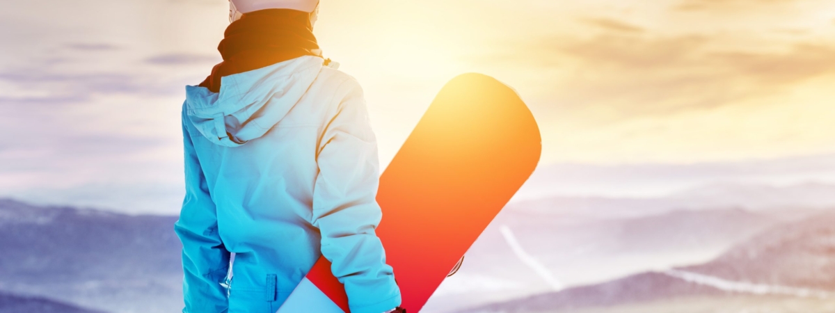 Girl,Snowboarder,Stands,With,Snowboard,On,Mountain's,Top,On,Sunrise