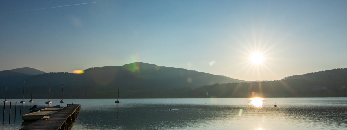 Beautiful landscape shot by the water. A dreamy sunset with reflections in the water. Lake Chiemsee, Bavaria, Germany