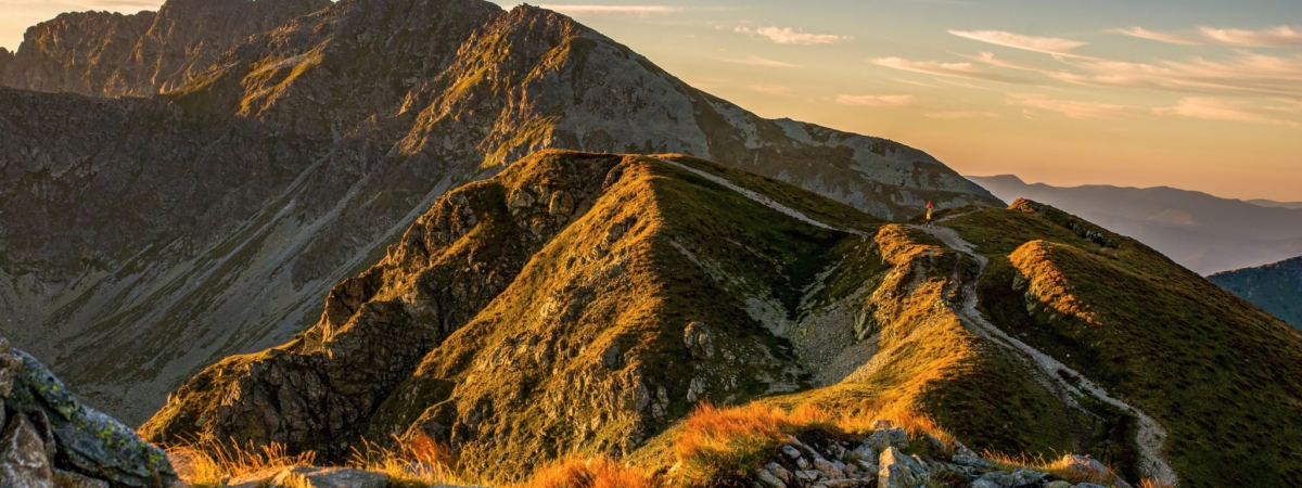 Sunrise from the ridge of the Western Tatras, Rohace with a view of the Salatin mountain with grass illuminated by the rising sun, camping and bivouac in nature. Tatras, tourist theme, tourist trail.